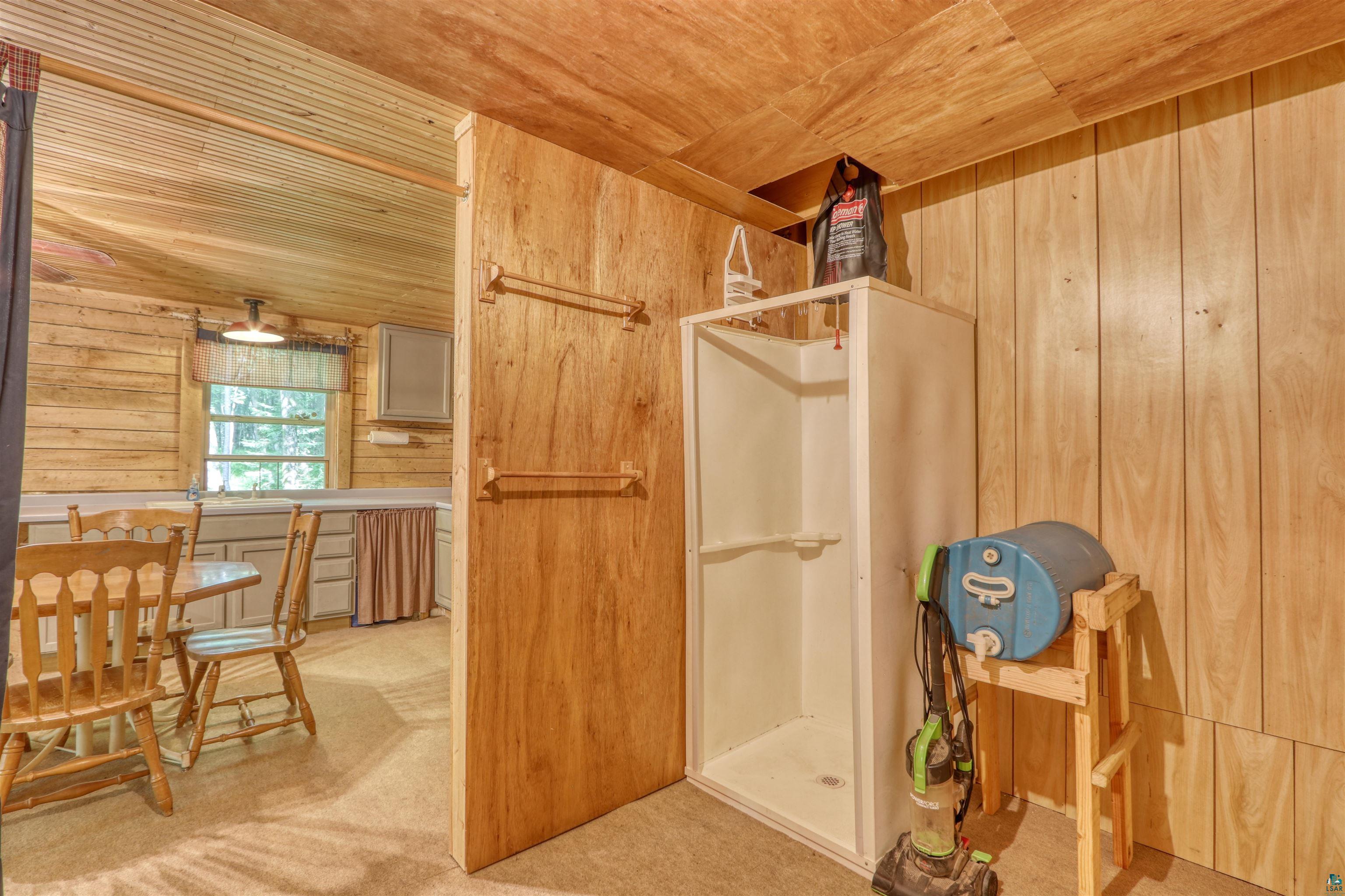 6676 Golf Course Road Winter, WI 54896 - Photo 29 of 51 Bathroom with wood walls, wooden ceiling, and a walk in shower