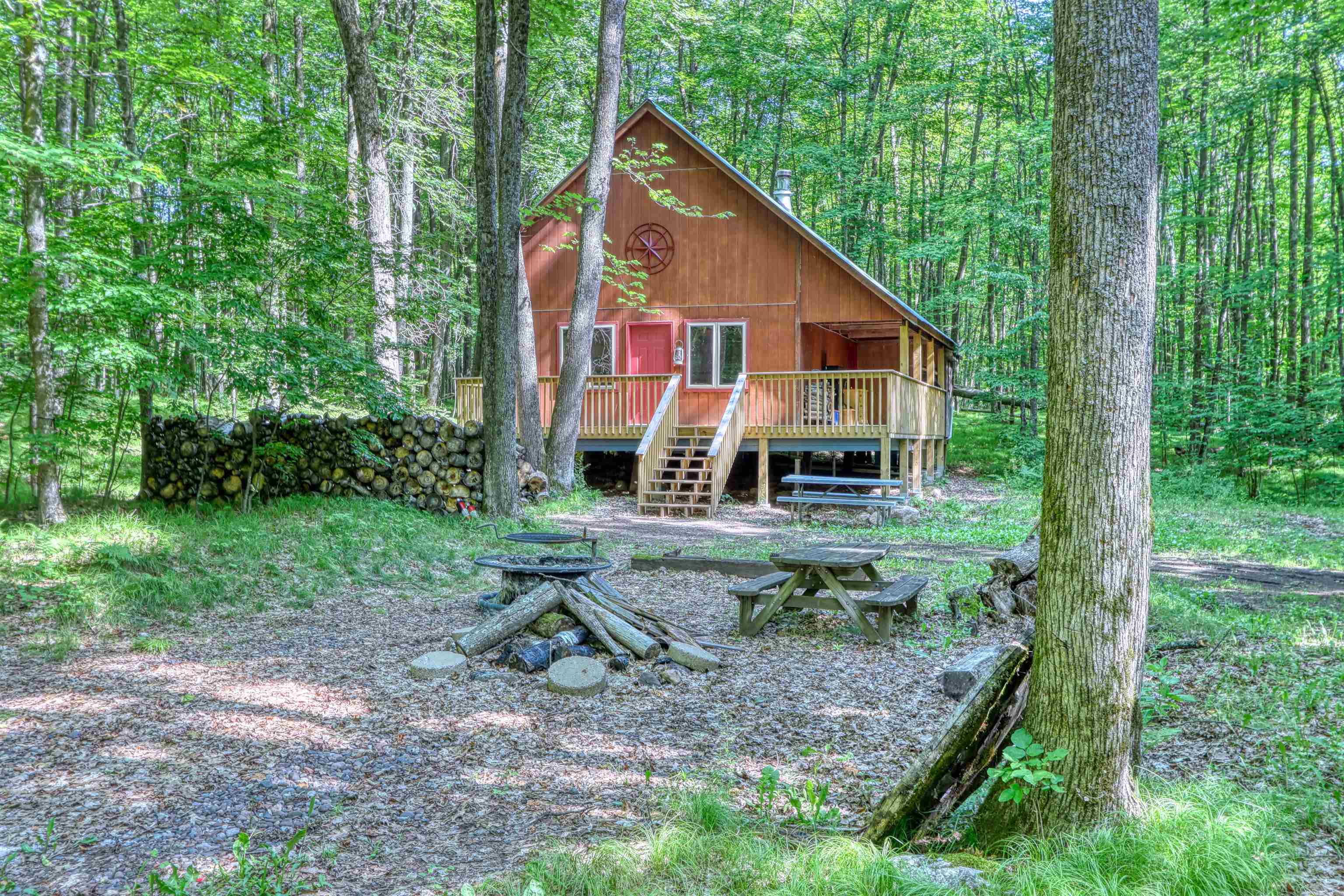 6676 Golf Course Road Winter, WI 54896 - Photo 44 of 51 Back of property with an outdoor fire pit, a wooden deck, and a forest view