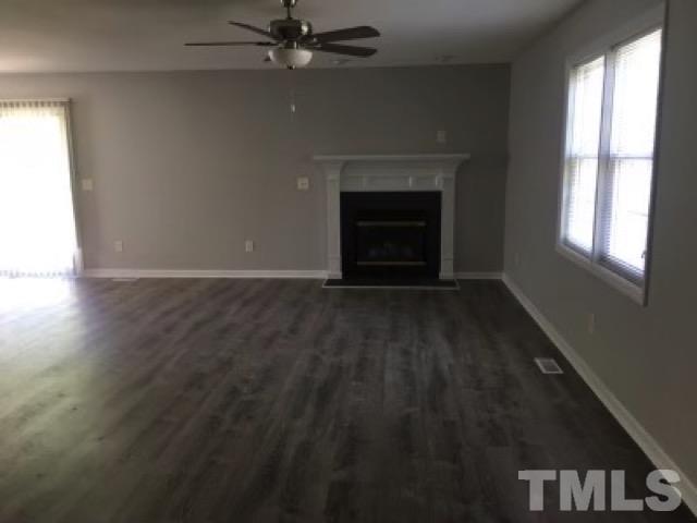 2717 Denbel Circle Raleigh, NC 27604 - Photo 1 of 16 an empty room with windows fireplace and fan