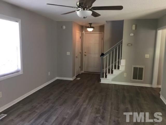 2717 Denbel Circle Raleigh, NC 27604 - Photo 2 of 16 an empty room with wooden floor fan and windows