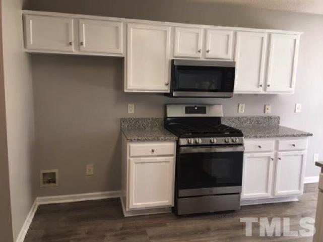 2717 Denbel Circle Raleigh, NC 27604 - Photo 4 of 16 a kitchen with granite countertop white cabinets and stainless steel appliances