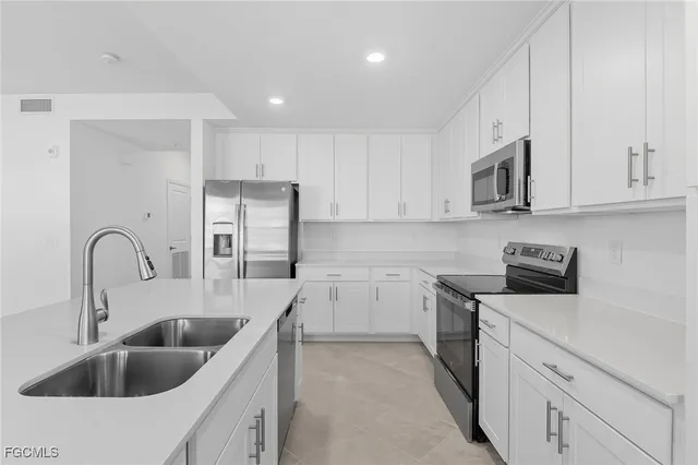 a kitchen with white cabinets a sink and a stove oven