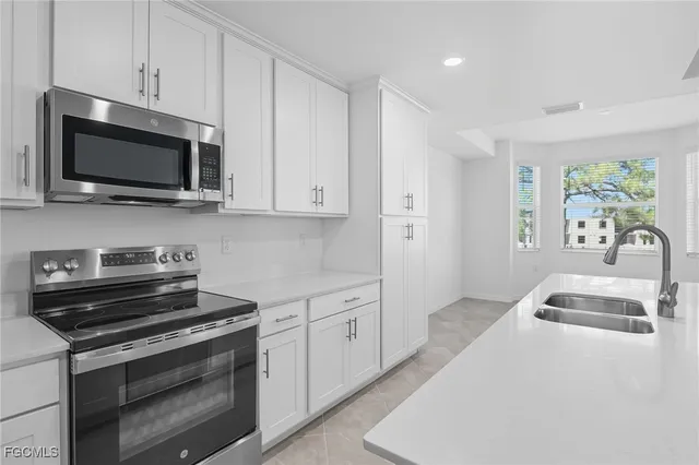 a kitchen with stainless steel appliances a stove a microwave sink and cabinets