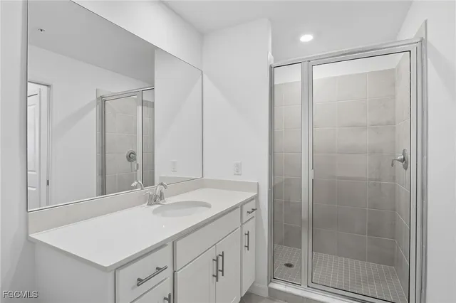 a bathroom with a shower sink and mirror