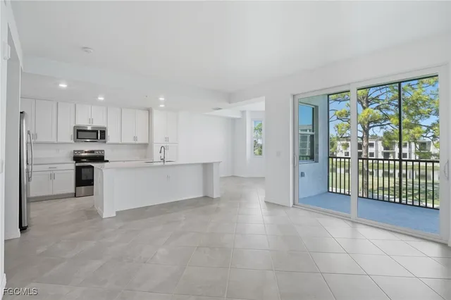 a large kitchen with a large window and stainless steel appliances