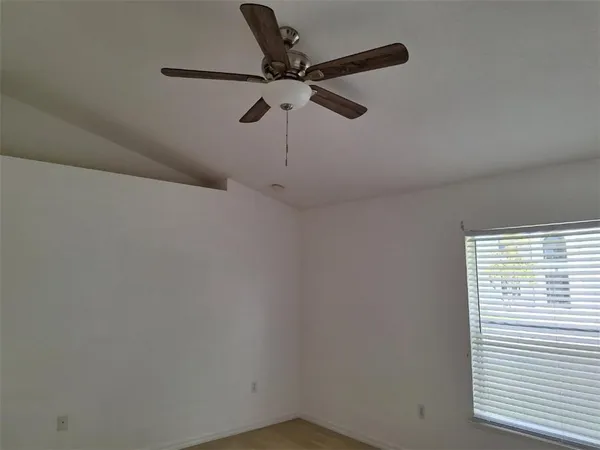 a wall with a window and a ceiling fan