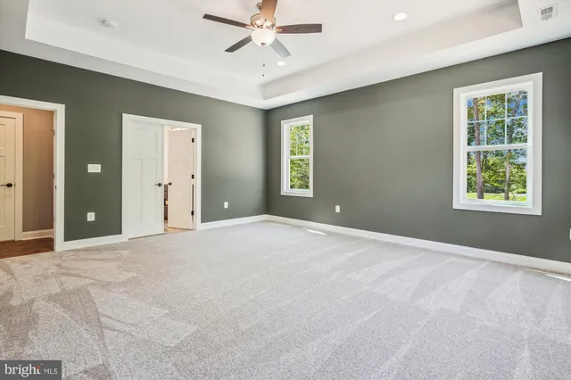 an empty room with closet and fan