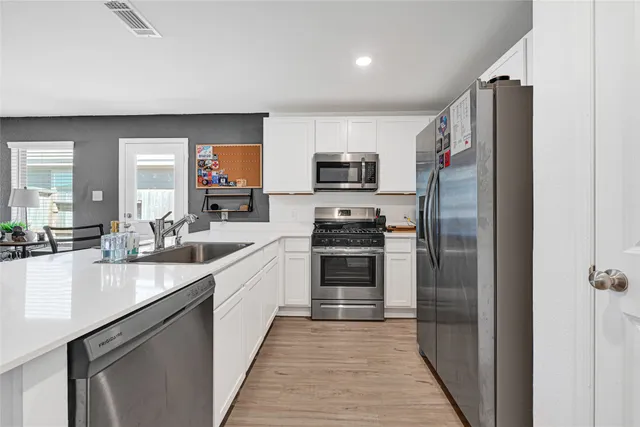 a kitchen with stainless steel appliances a refrigerator sink and cabinets