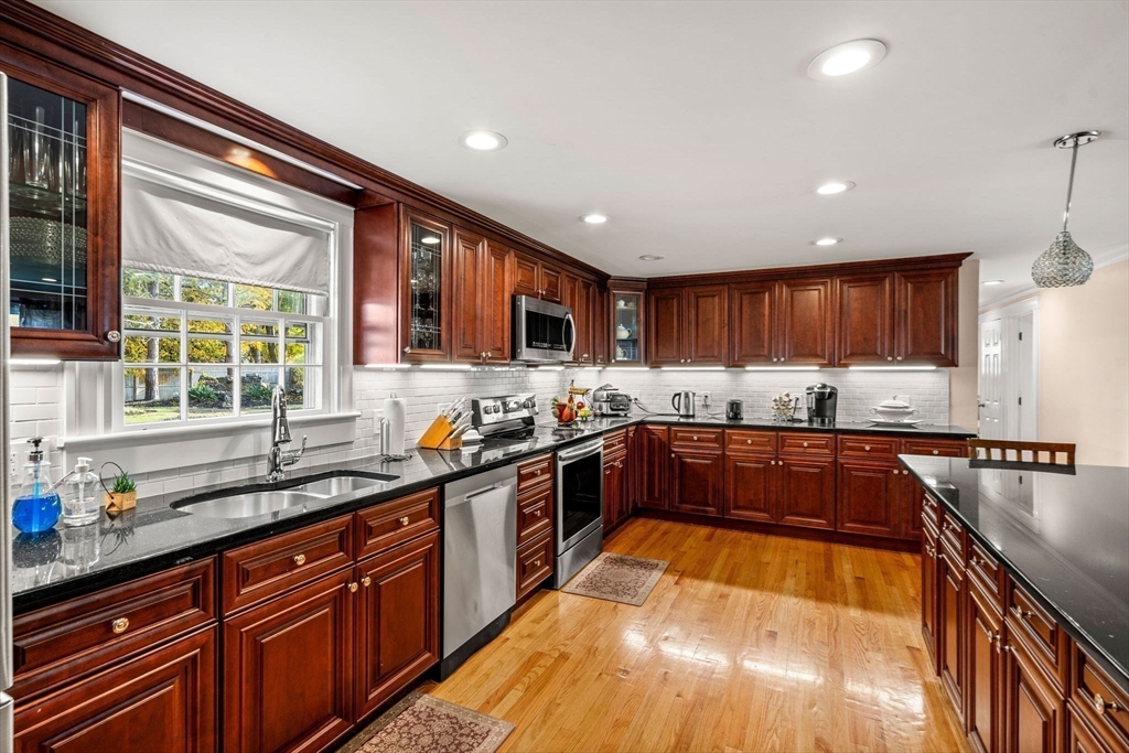 13 Sunnyvale Street Beverly, MA 01915 - Photo 8 of 18 a large kitchen with stainless steel appliances granite countertop a sink and wooden cabinets