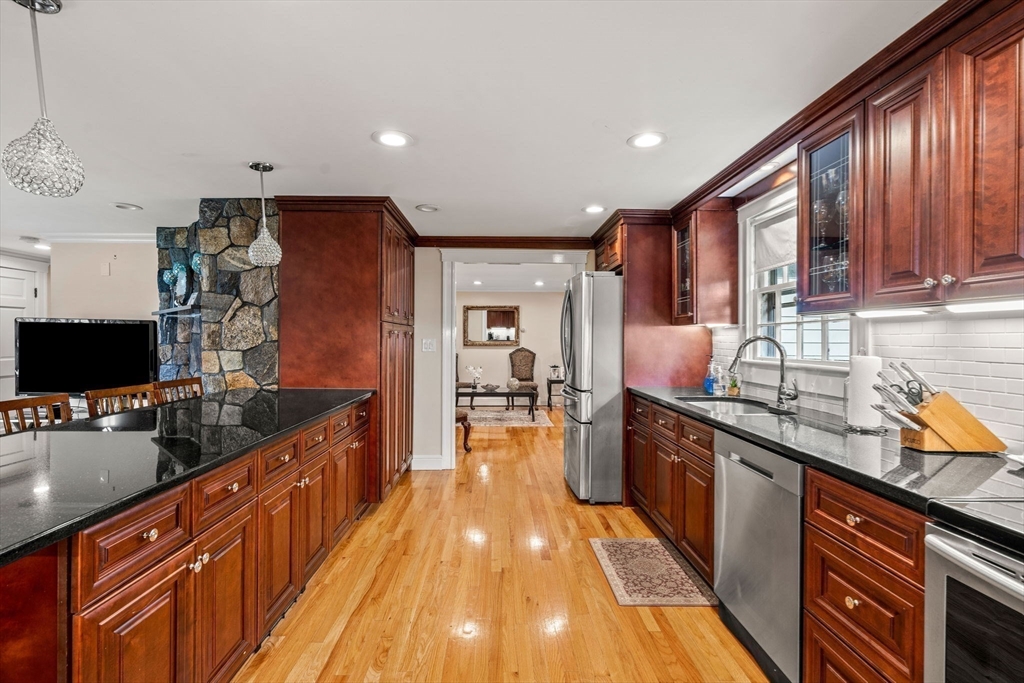 13 Sunnyvale Street Beverly, MA 01915 - Photo 9 of 18 a large kitchen with stainless steel appliances granite countertop a stove and cabinets