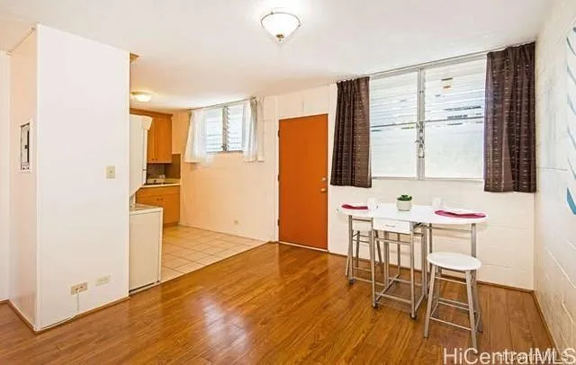 a dining room with wooden floor and large window