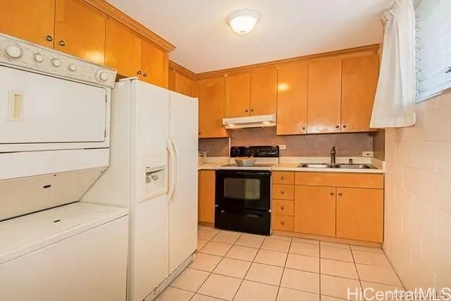 a kitchen with a refrigerator a stove top oven and cabinets
