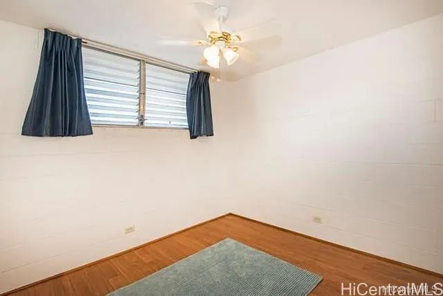 a view of a room with a ceiling fan and a window