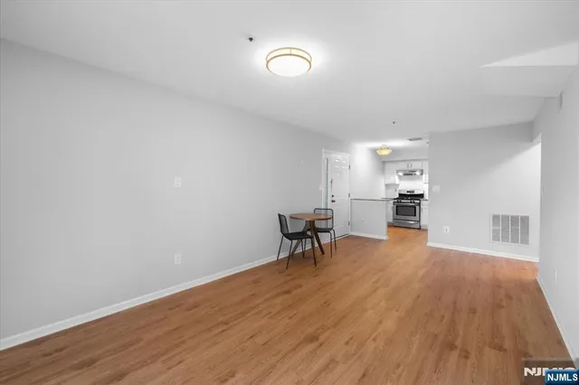 a big room with wooden floor and kitchen