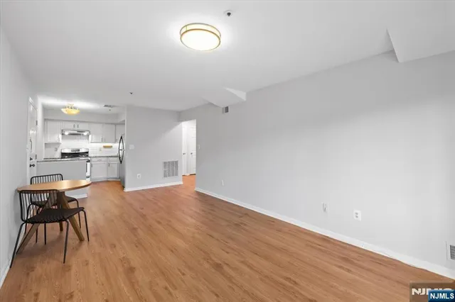a kitchen with stainless steel appliances a refrigerator stove and white cabinets