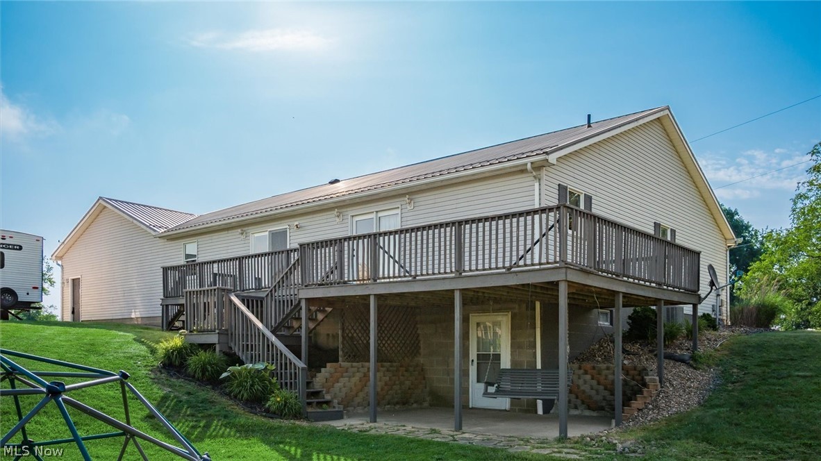 9393 Pioneer Road Byesville, OH 43723 - Photo 27 of 35 Rear view of house featuring a lawn, a patio area, and a wooden deck