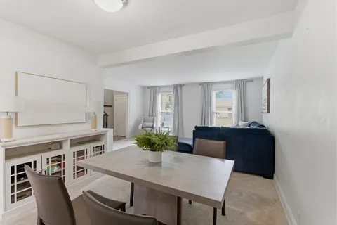 a living room with furniture and a dining table