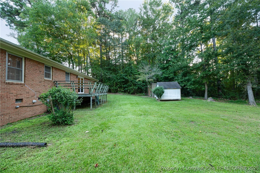 2470 Hickory House Road Sanford, NC 27332 - Photo 19 of 27 a backyard of a house with a garden and plants