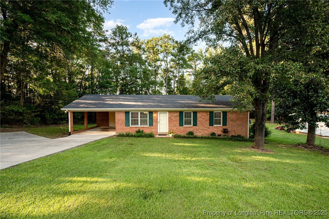 2470 Hickory House Road Sanford, NC 27332 - Photo 2 of 27 a front view of a house with a garden