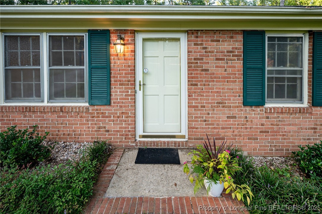 2470 Hickory House Road Sanford, NC 27332 - Photo 27 of 27 a front view of a house with a window and potted plants