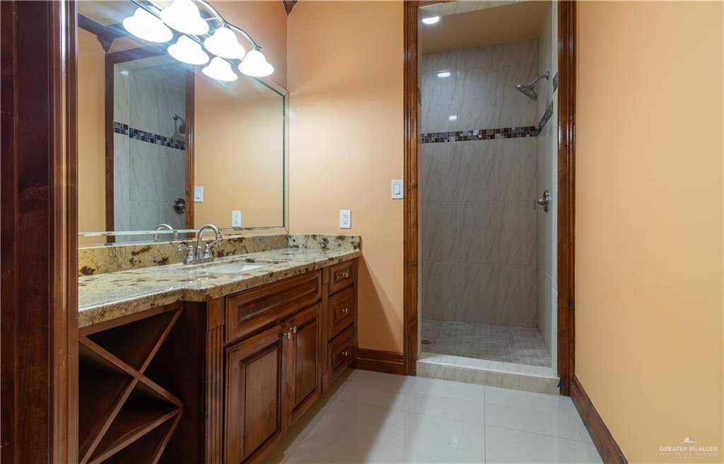 2204 East Trenton Road Edinburg, TX 78542 - Photo 11 of 37 a bathroom with a granite countertop sink a mirror and a shower