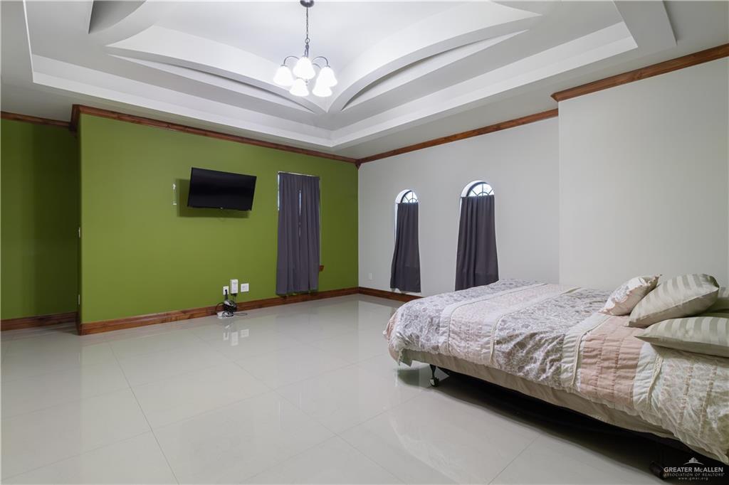 2204 East Trenton Road Edinburg, TX 78542 - Photo 13 of 37 a spacious bedroom with a bed and a chandelier