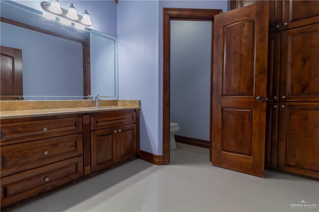 2204 East Trenton Road Edinburg, TX 78542 - Photo 25 of 37 a spacious bathroom with a granite countertop sink and a mirror