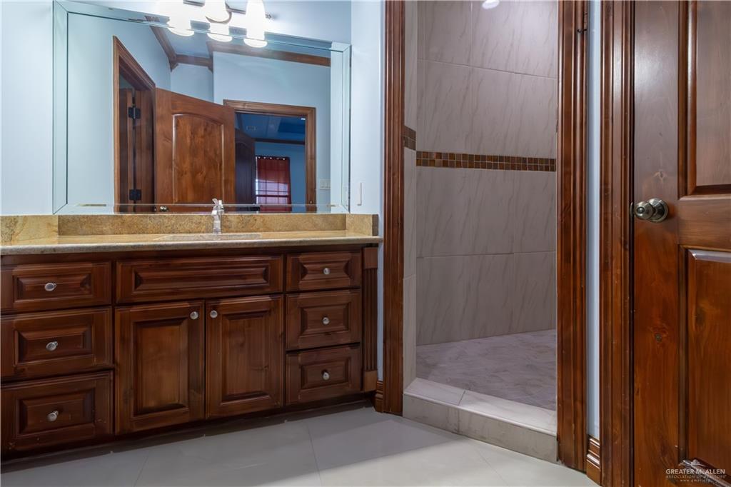 2204 East Trenton Road Edinburg, TX 78542 - Photo 27 of 37 a spacious bathroom with a granite countertop sink a mirror and shower