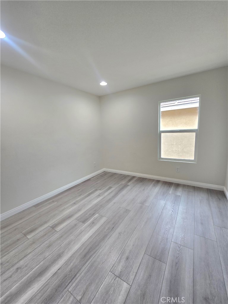 3073 Snowdrop Court Perris, CA 92571 - Photo 16 of 25 an empty room with wooden floor and windows