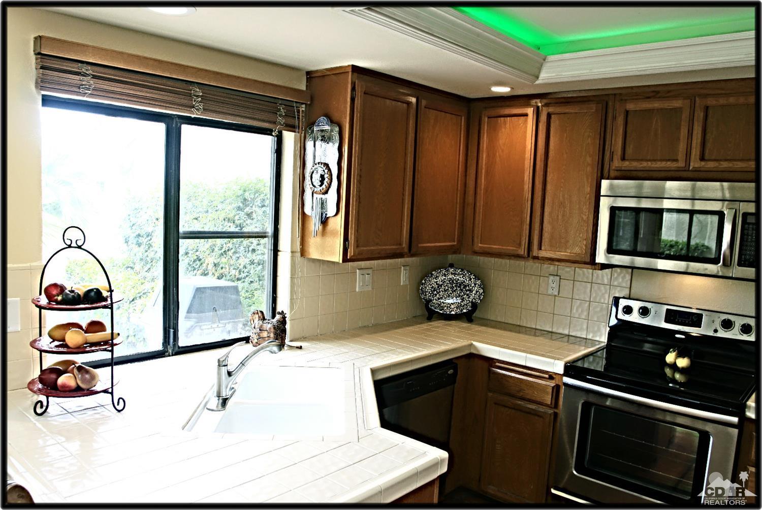 42872 Scirocco Road Palm Desert, CA 92211 - Photo 11 of 23 a kitchen with stainless steel appliances kitchen island granite countertop a sink and a stove