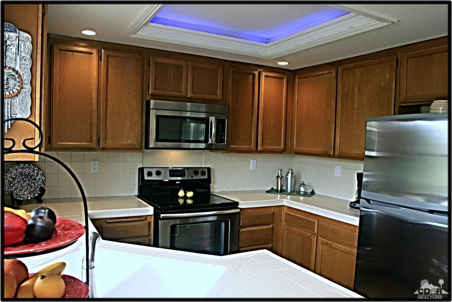 42872 Scirocco Road Palm Desert, CA 92211 - Photo 12 of 23 a kitchen with stainless steel appliances granite countertop a stove a sink and a microwave