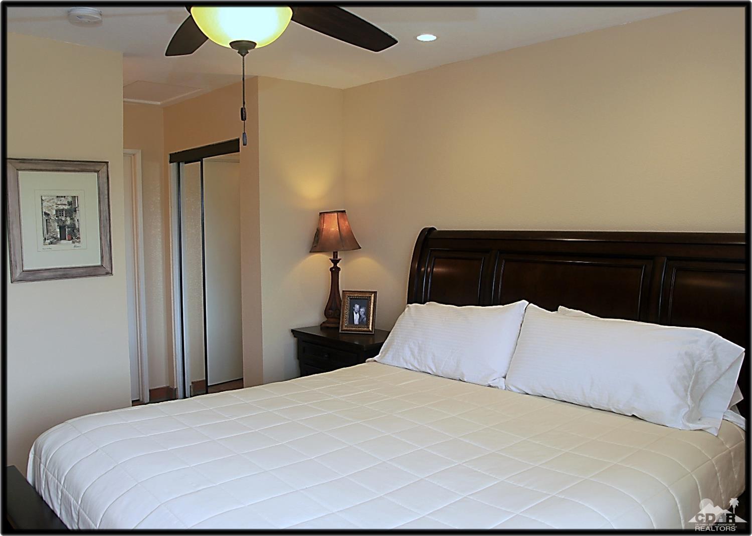 42872 Scirocco Road Palm Desert, CA 92211 - Photo 15 of 23 a bedroom with a bed and wooden floor