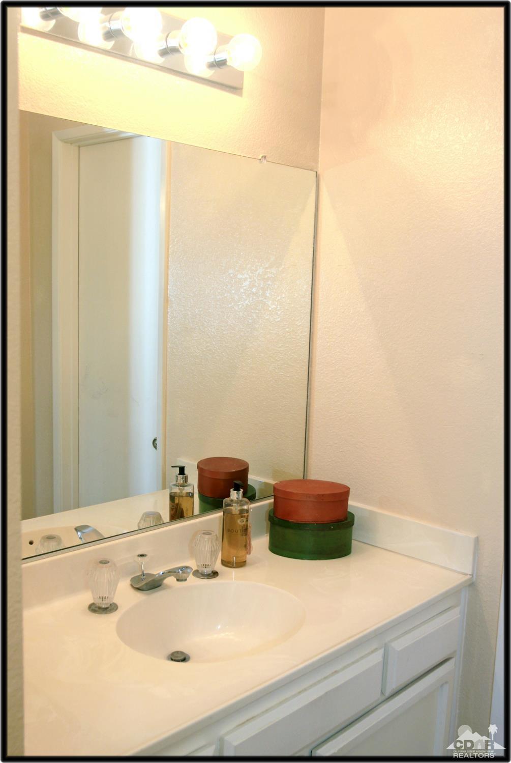 42872 Scirocco Road Palm Desert, CA 92211 - Photo 16 of 23 a bathroom with a sink and a mirror