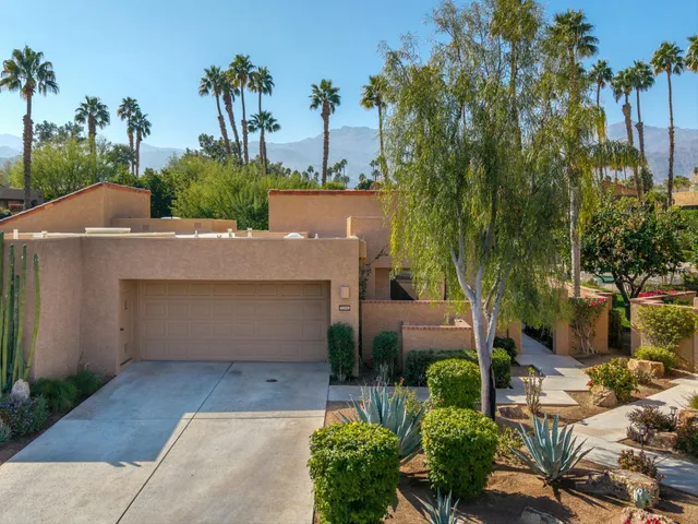 view of a house with a yard and potted plants