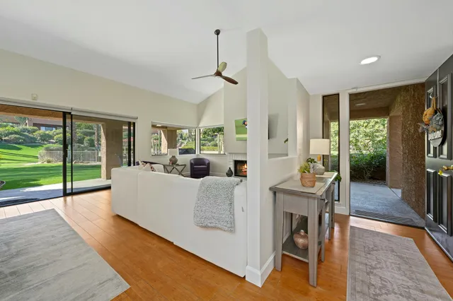 a living room with furniture a fireplace and a floor to ceiling window