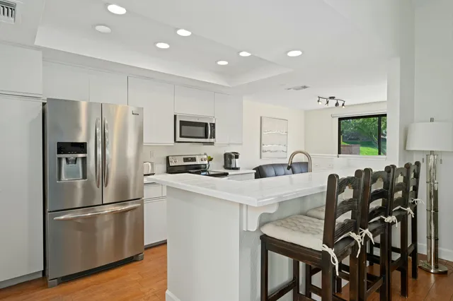 a kitchen with a sink a counter top space a stove a refrigerator cabinets and a sink