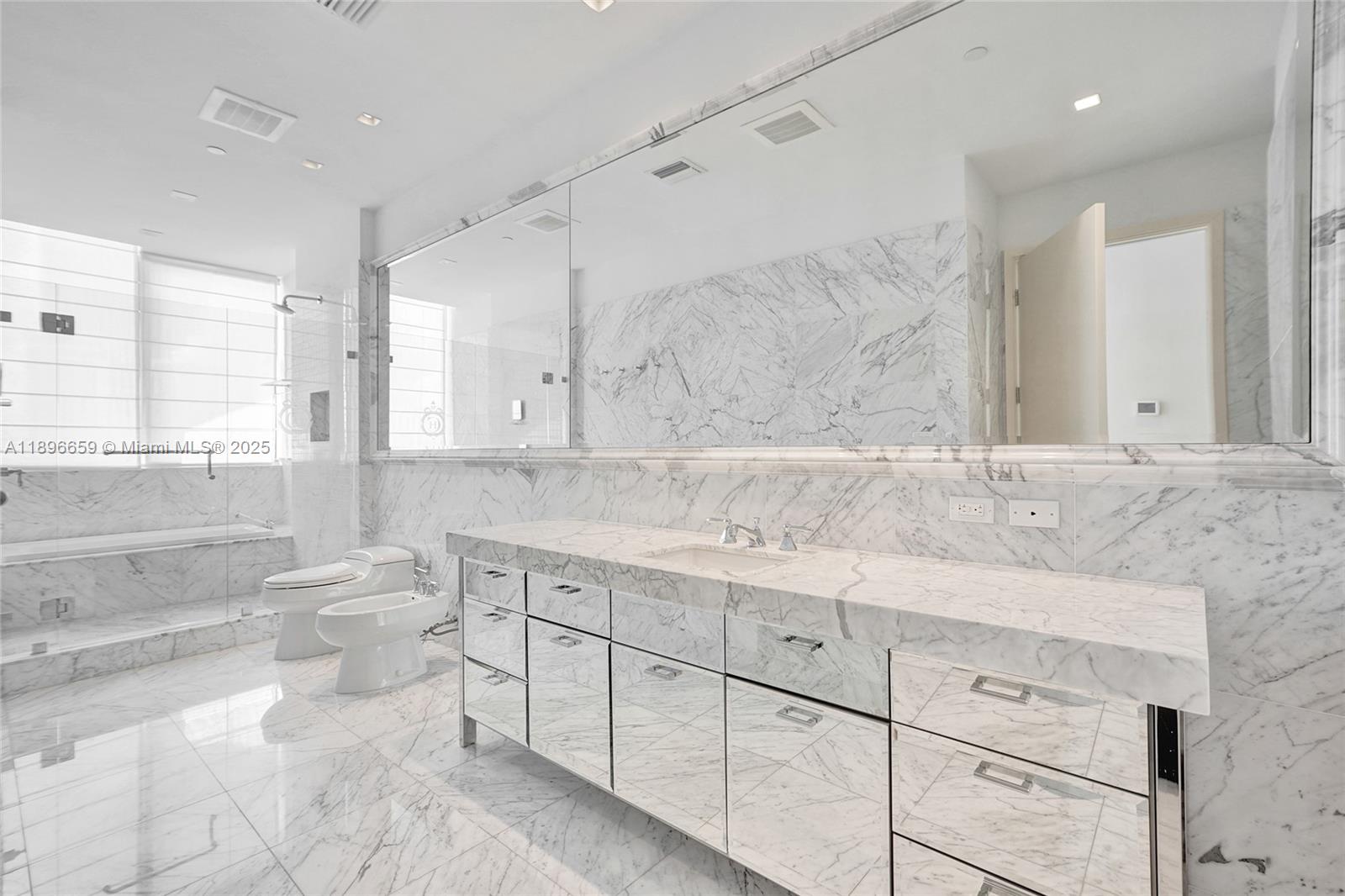 17475 Collins Avenue, Unit 2302 Sunny Isles Beach, FL 33160 - Photo 13 of 42 a bathroom with a granite countertop sink mirror and a toilet