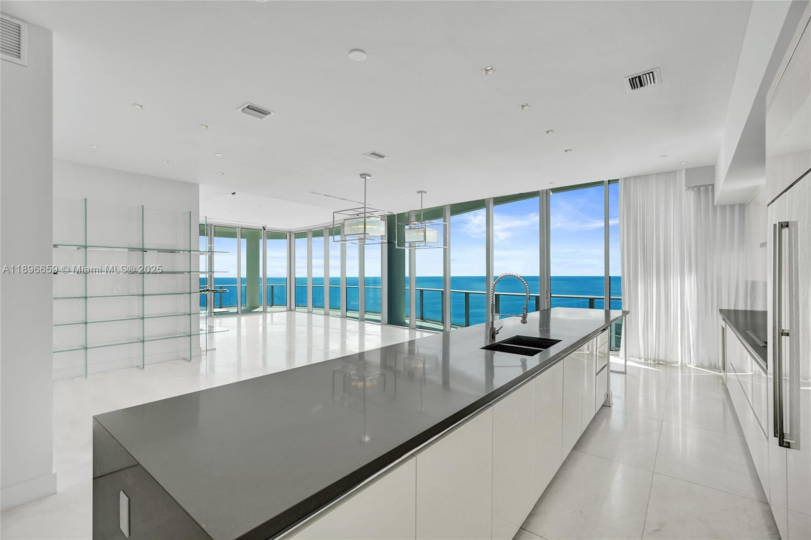 17475 Collins Avenue, Unit 2302 Sunny Isles Beach, FL 33160 - Photo 2 of 42 a view of a kitchen with kitchen island a large window a sink and a counter top space