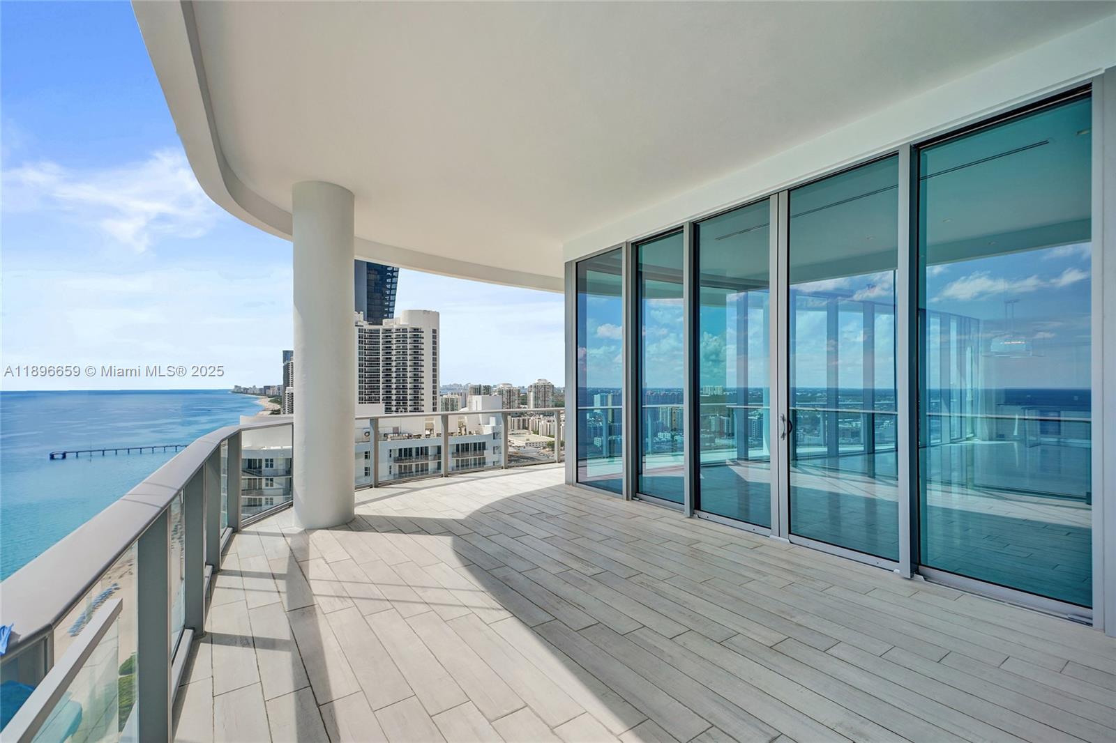 17475 Collins Avenue, Unit 2302 Sunny Isles Beach, FL 33160 - Photo 24 of 42 a room with wooden floor and balcony