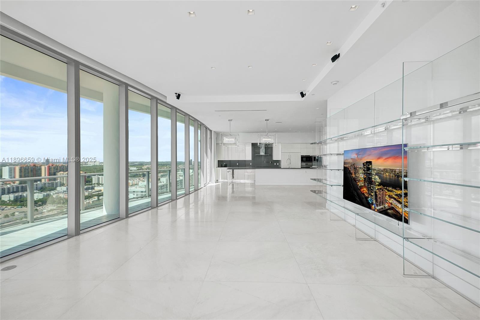 17475 Collins Avenue, Unit 2302 Sunny Isles Beach, FL 33160 - Photo 7 of 42 a view of a livingroom with furniture and a flat screen tv