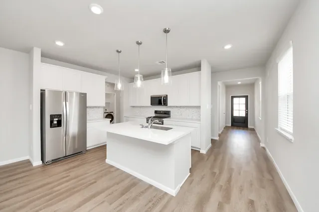 a view of kitchen with sink microwave and refrigerator