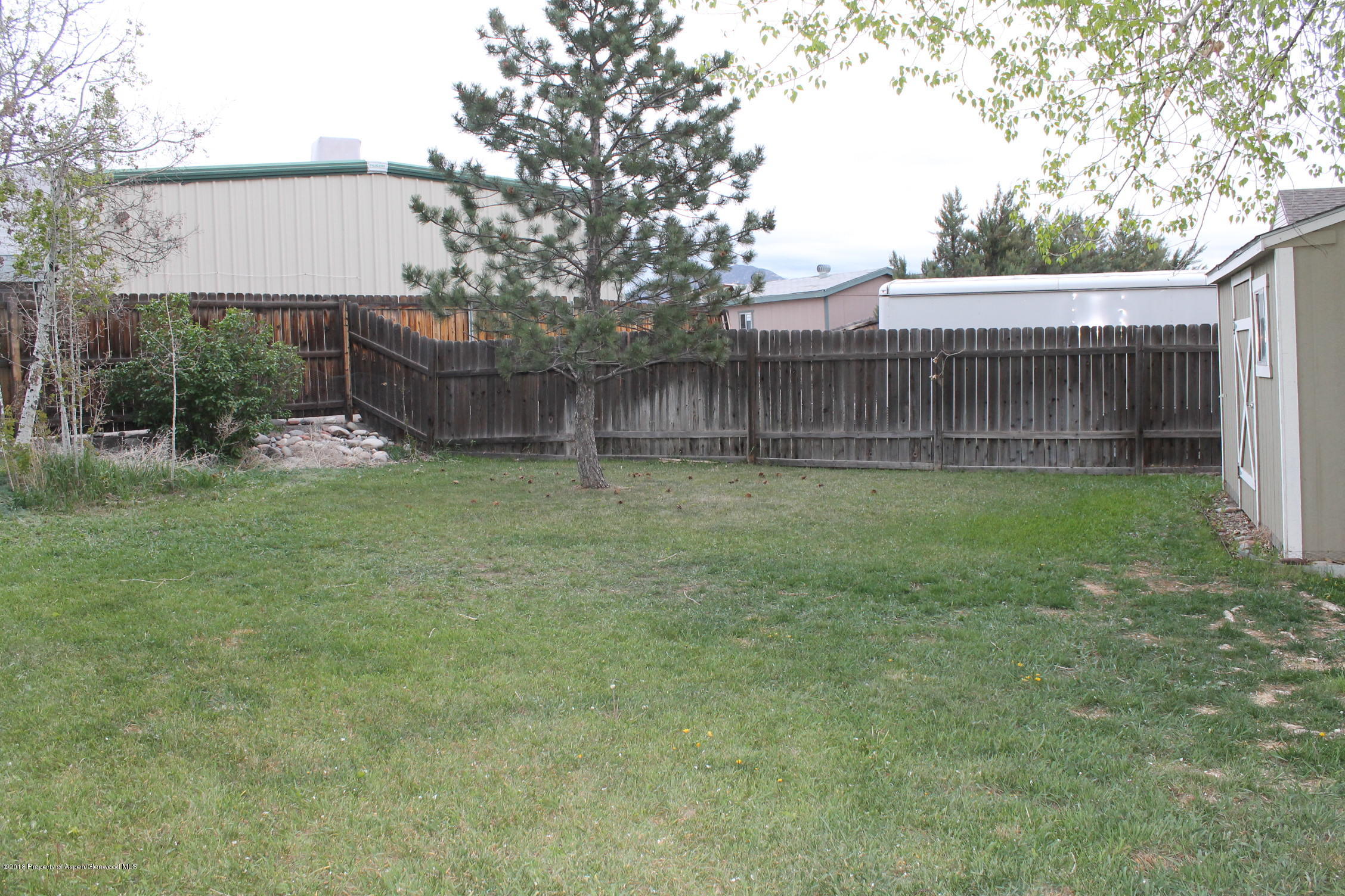 402 Columbine Court Rifle, CO 81650 - Photo 16 of 19 a backyard of a house with table and chairs