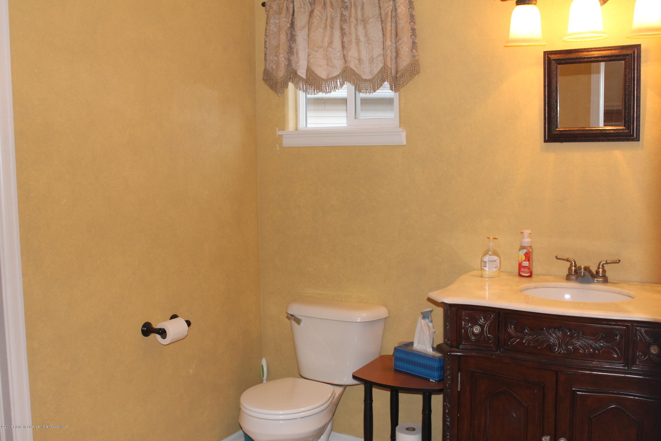 402 Columbine Court Rifle, CO 81650 - Photo 5 of 19 a bathroom with a sink a toilet and mirror