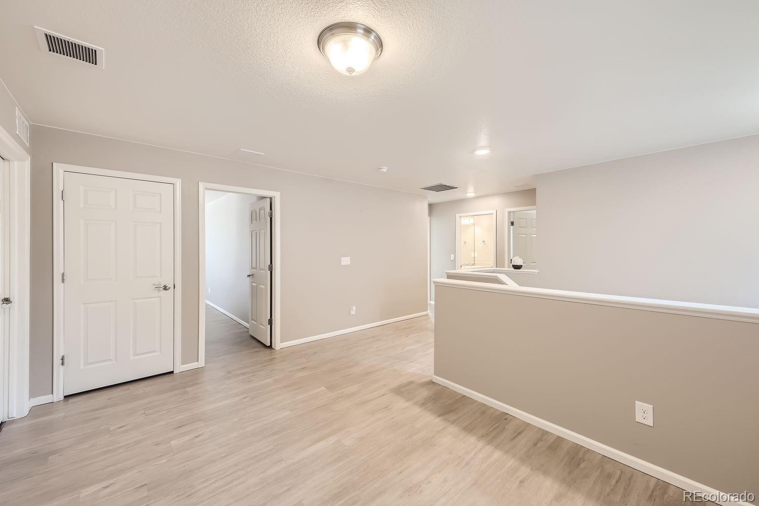6808 Morrison Drive Frederick, CO 80530 - Photo 13 of 28 an empty room with wooden floor and windows