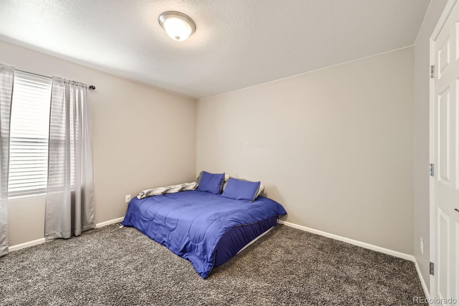 6808 Morrison Drive Frederick, CO 80530 - Photo 18 of 28 a spacious bedroom with a bed and a window