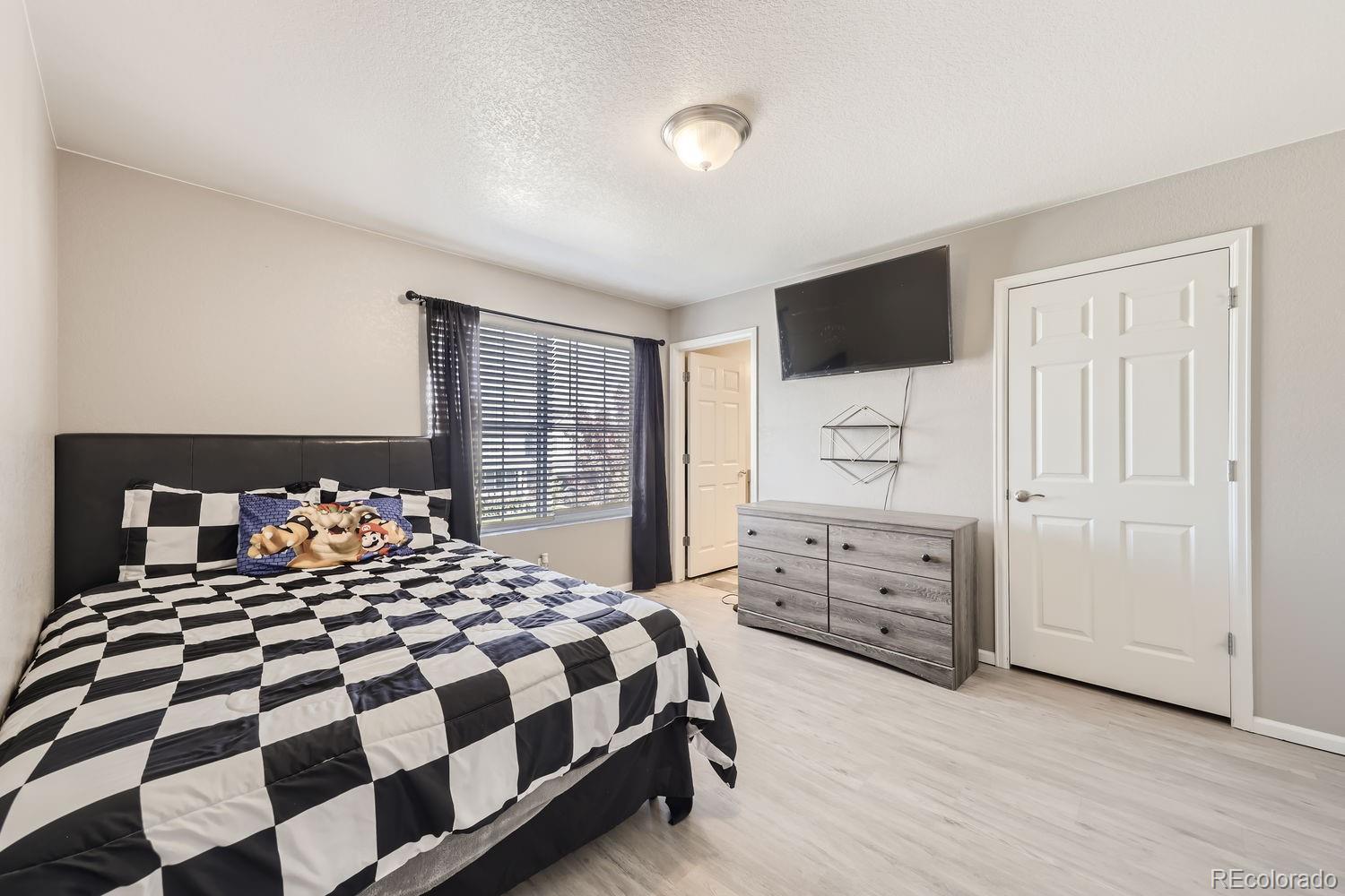 6808 Morrison Drive Frederick, CO 80530 - Photo 19 of 28 a bedroom with a bed and wooden floor