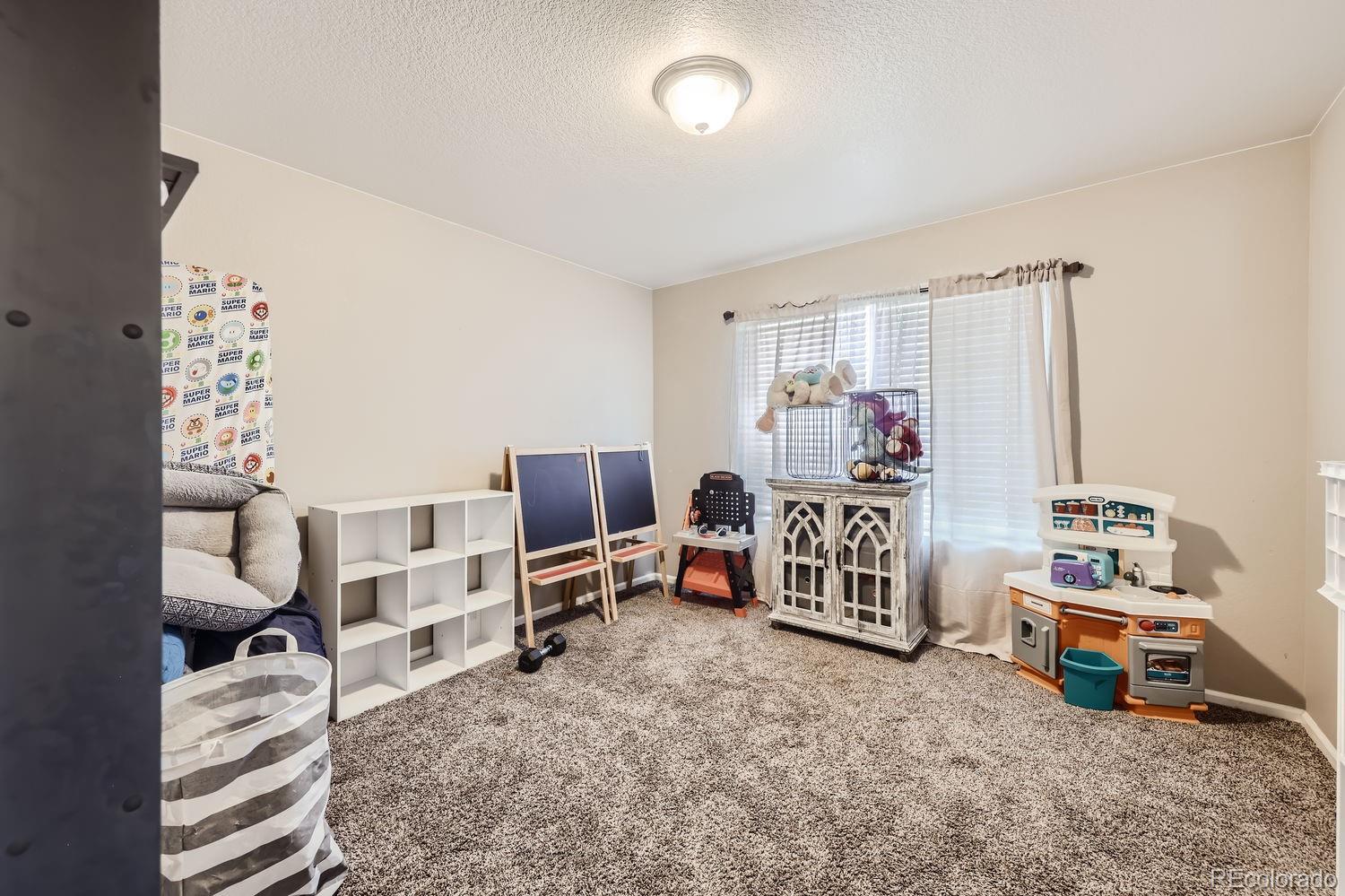6808 Morrison Drive Frederick, CO 80530 - Photo 20 of 28 a bedroom with furniture and a flat screen tv