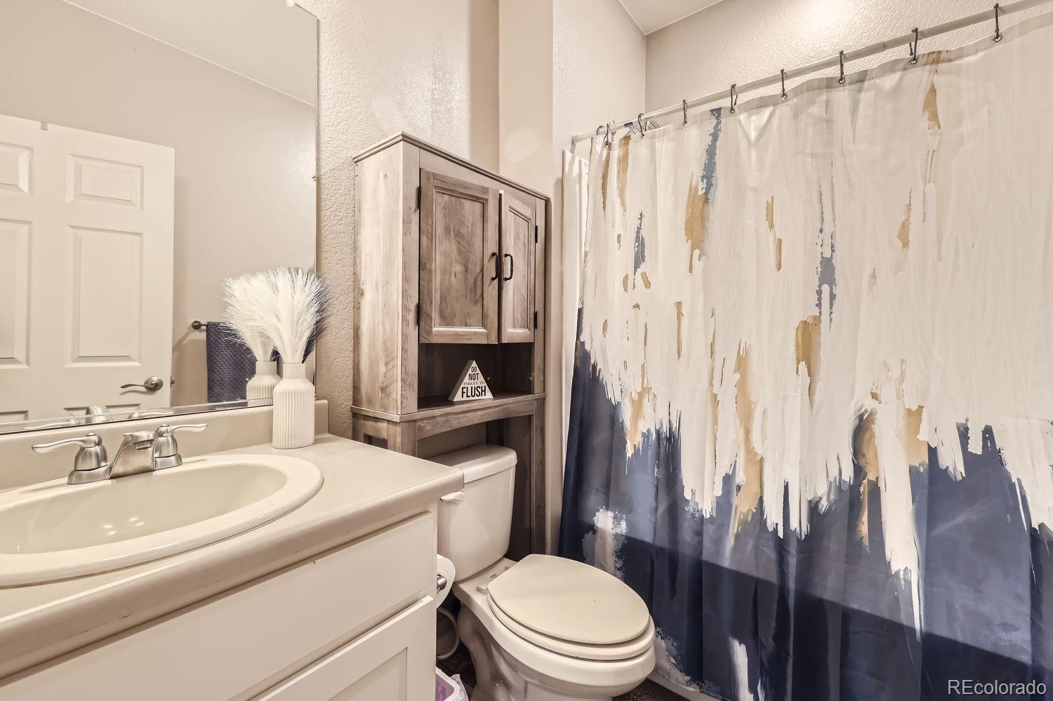 6808 Morrison Drive Frederick, CO 80530 - Photo 22 of 28 a bathroom with a sink a toilet a mirror and shower