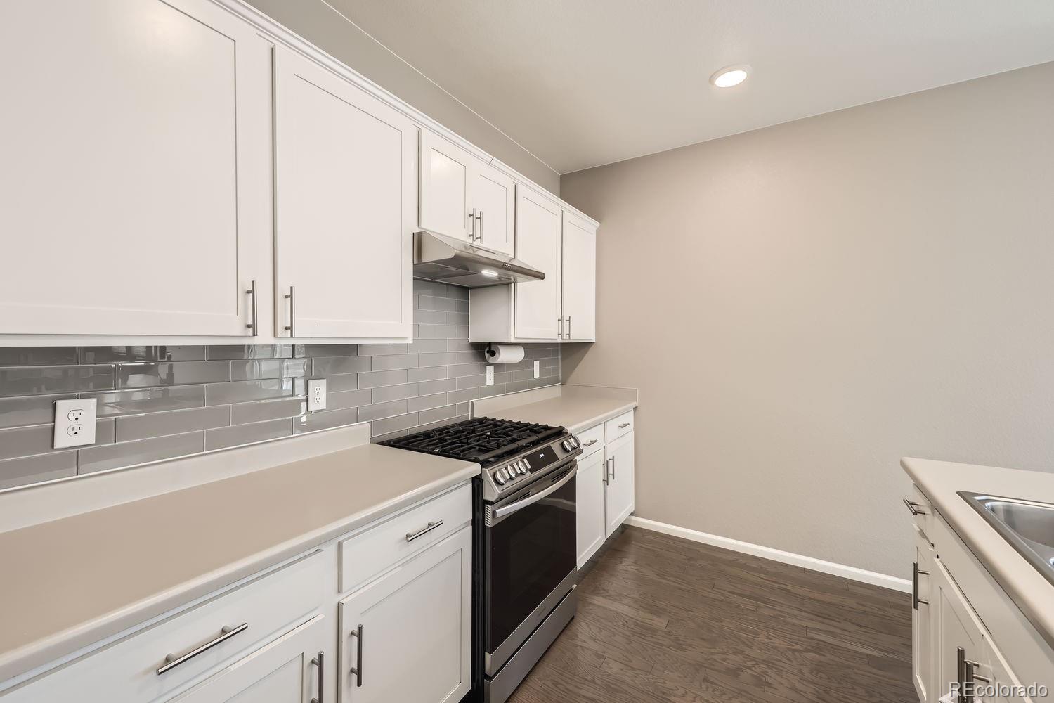 6808 Morrison Drive Frederick, CO 80530 - Photo 7 of 28 a kitchen with stainless steel appliances a sink a stove and white cabinets