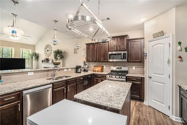 a kitchen with stainless steel appliances granite countertop a sink stove and refrigerator